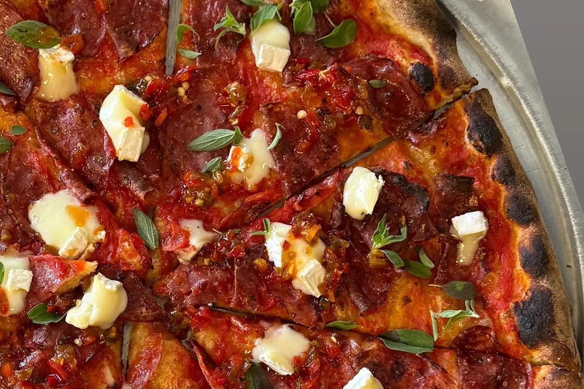 Specialty pie with soppressata, brie, hot honey and fresh oregano